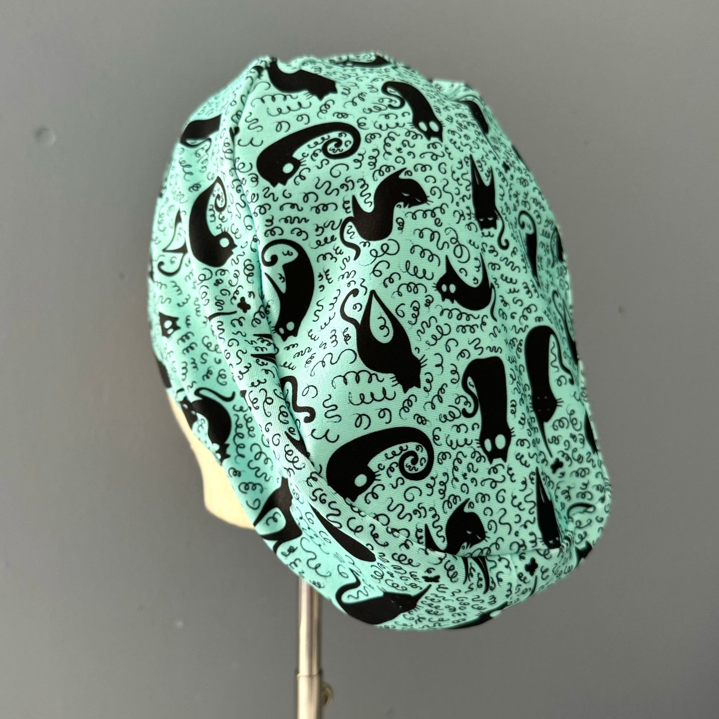 Cofia turquesa y gatos negros