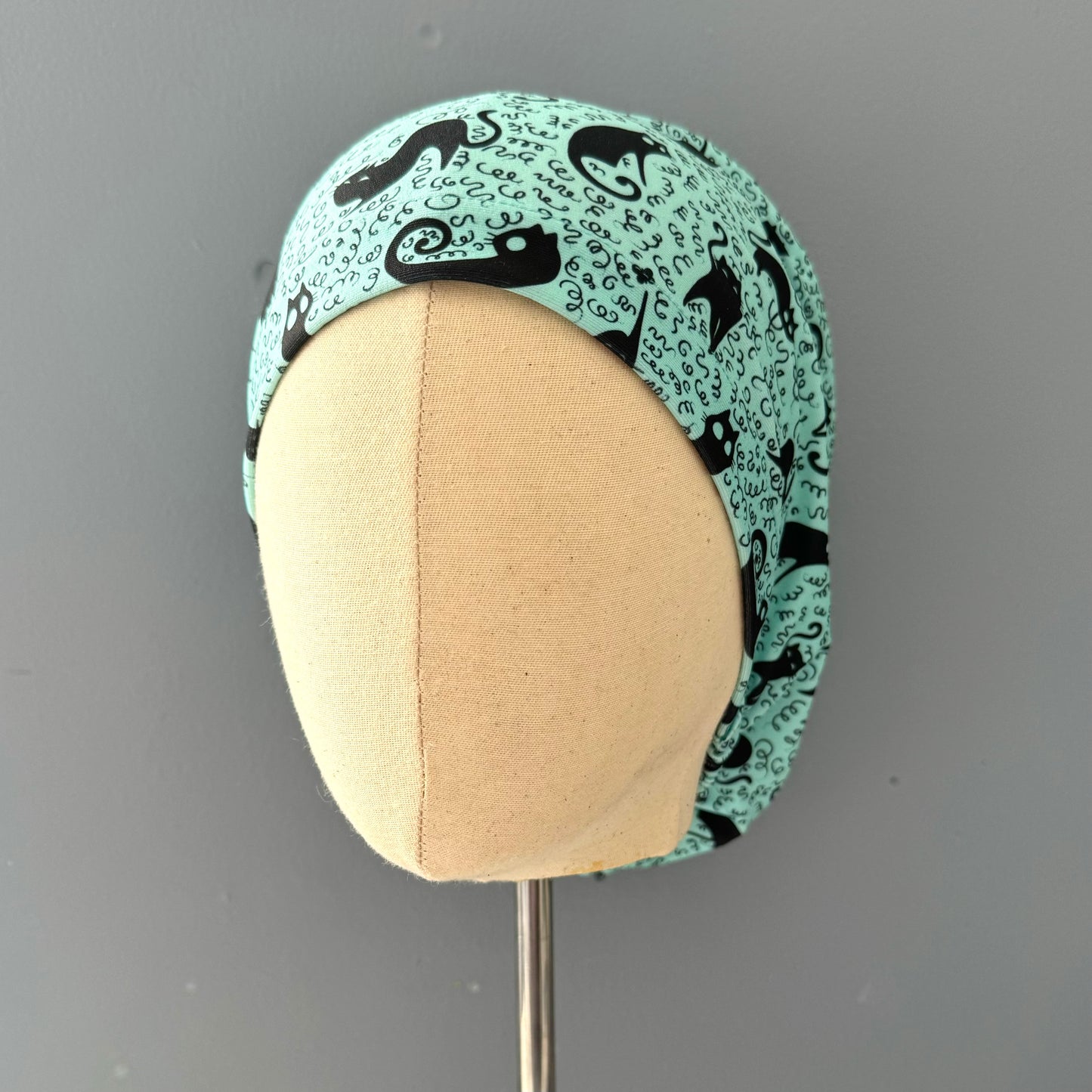 Cofia turquesa y gatos negros