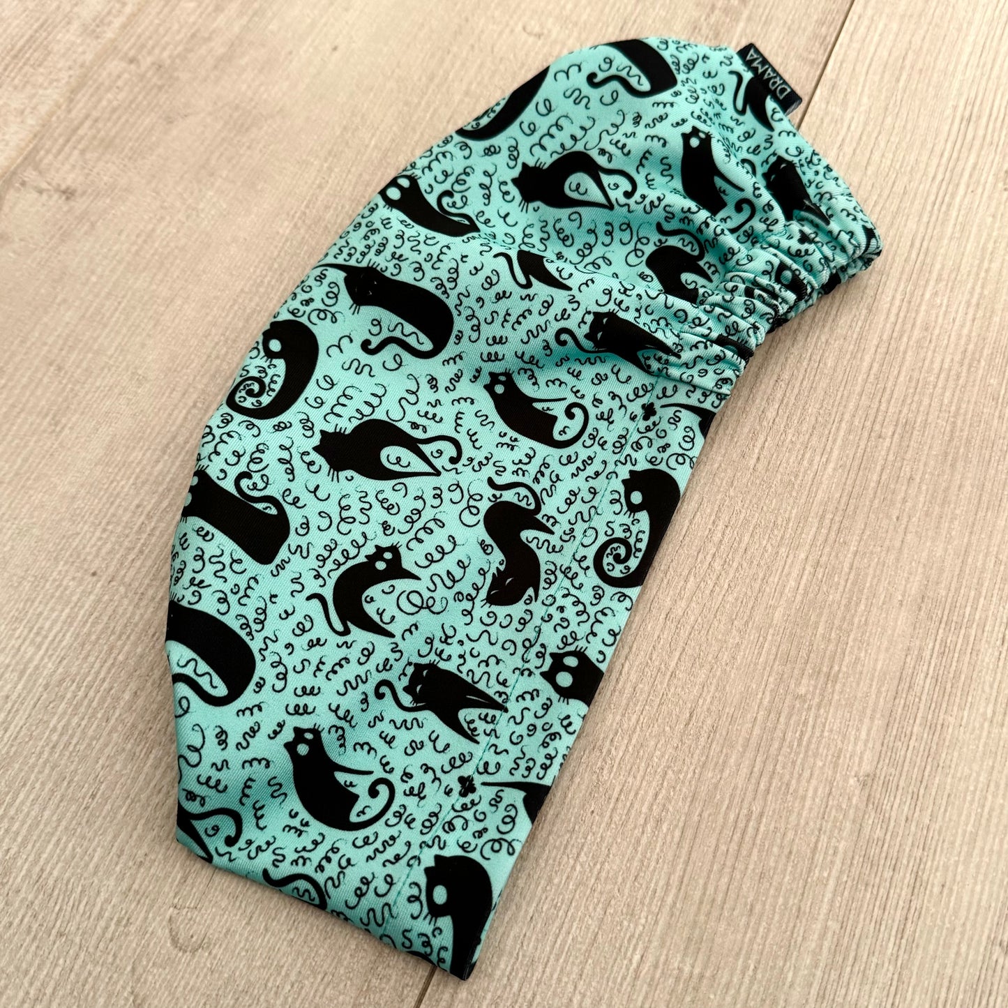 Cofia turquesa y gatos negros