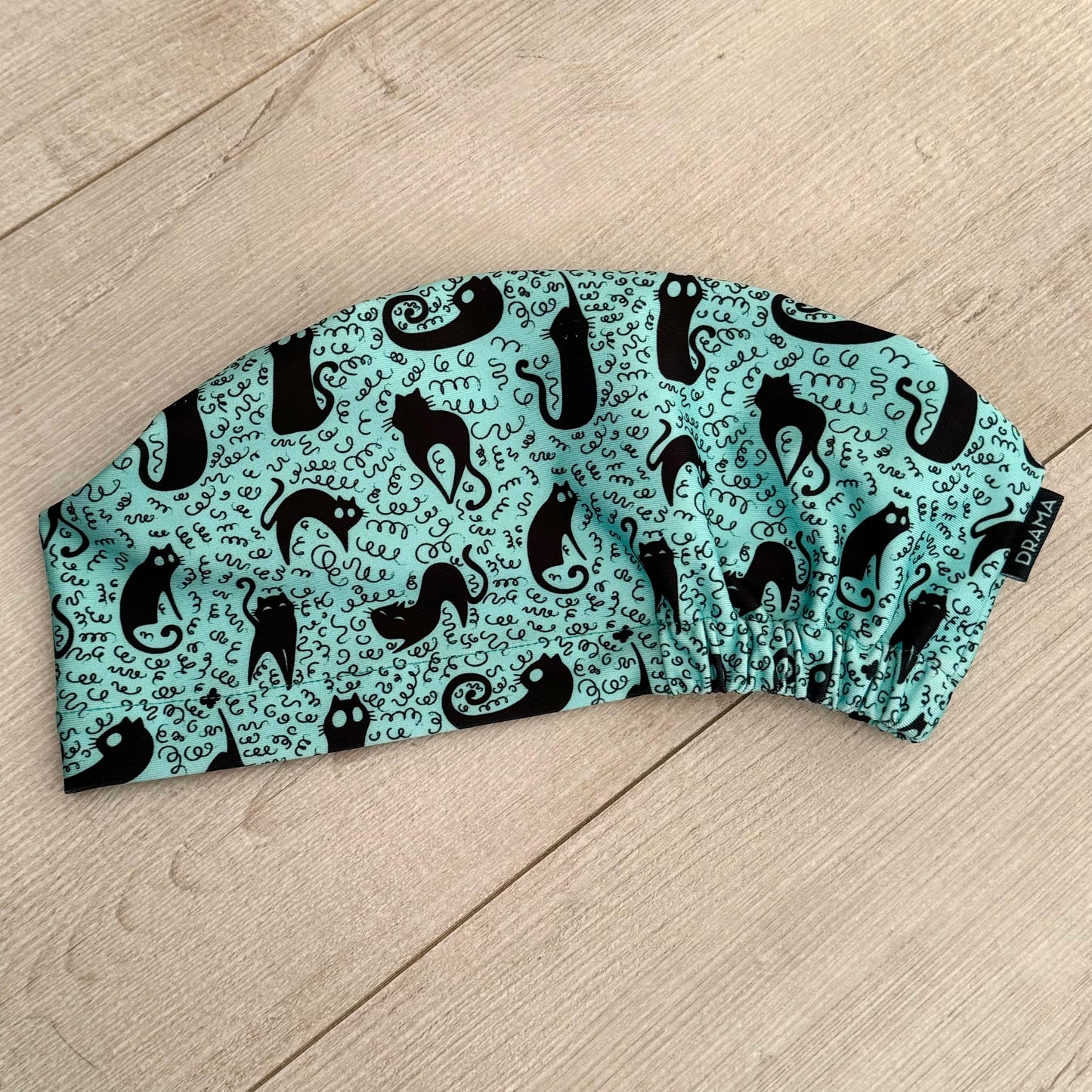 Cofia turquesa y gatos negros