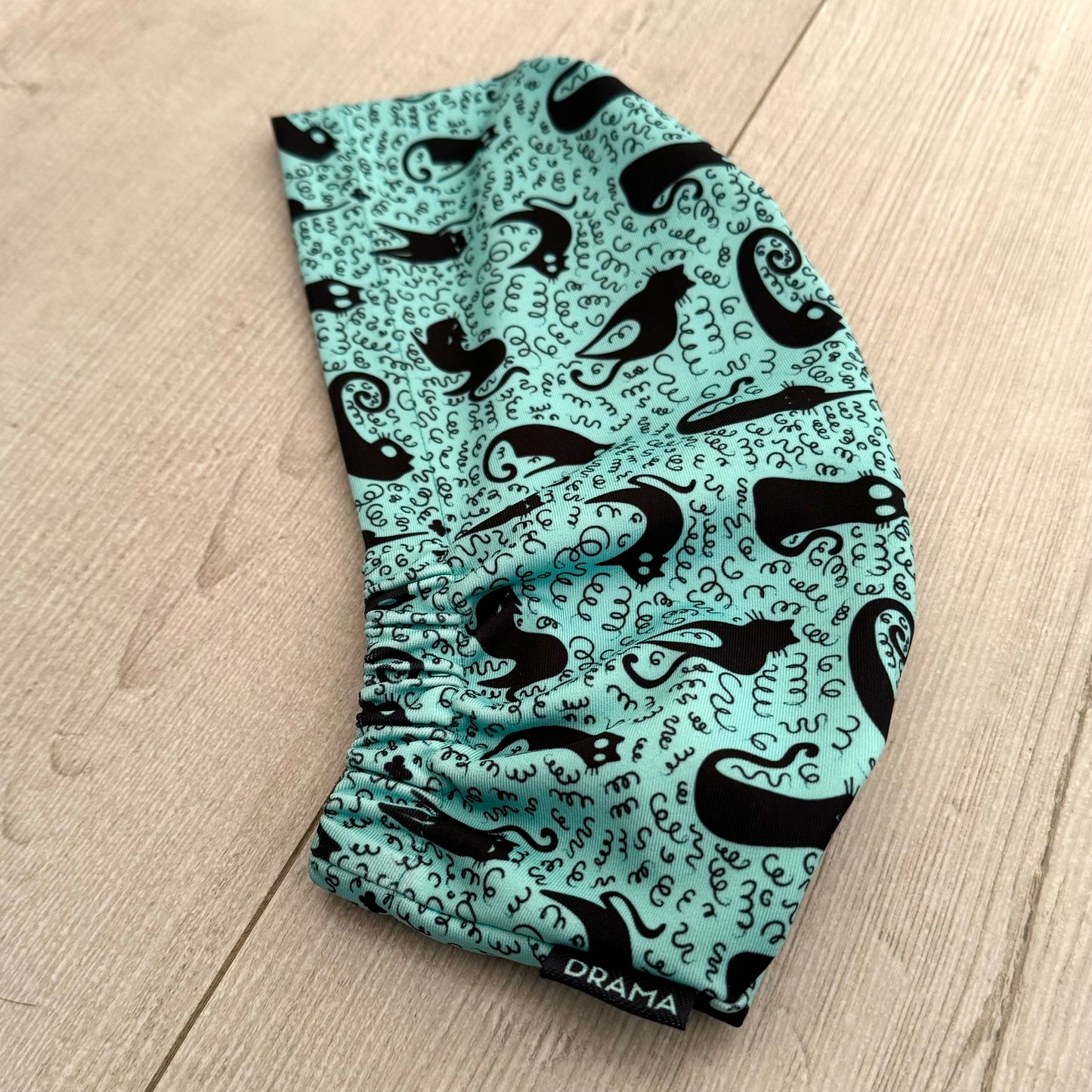 Cofia turquesa y gatos negros