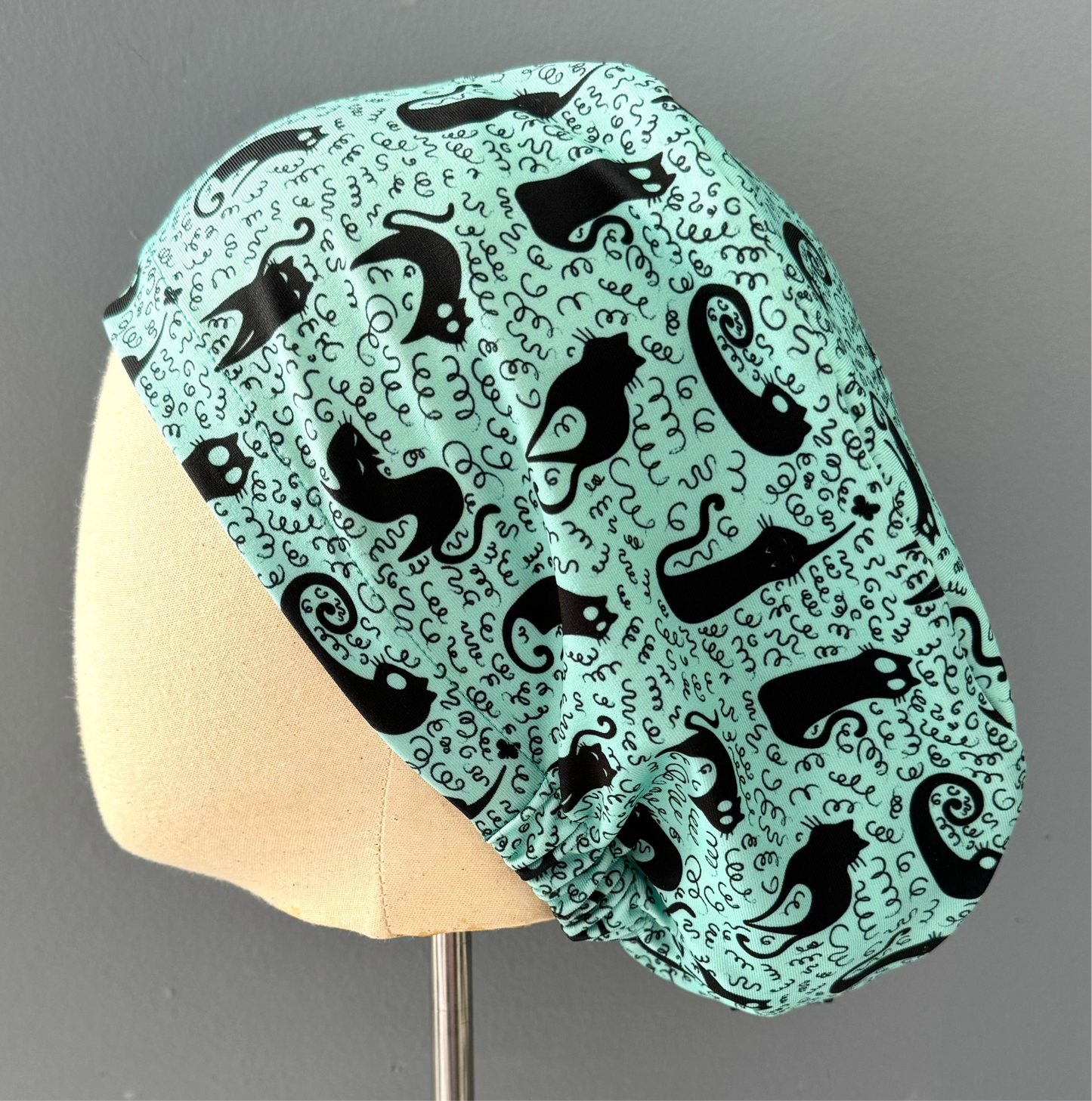 Cofia turquesa y gatos negros